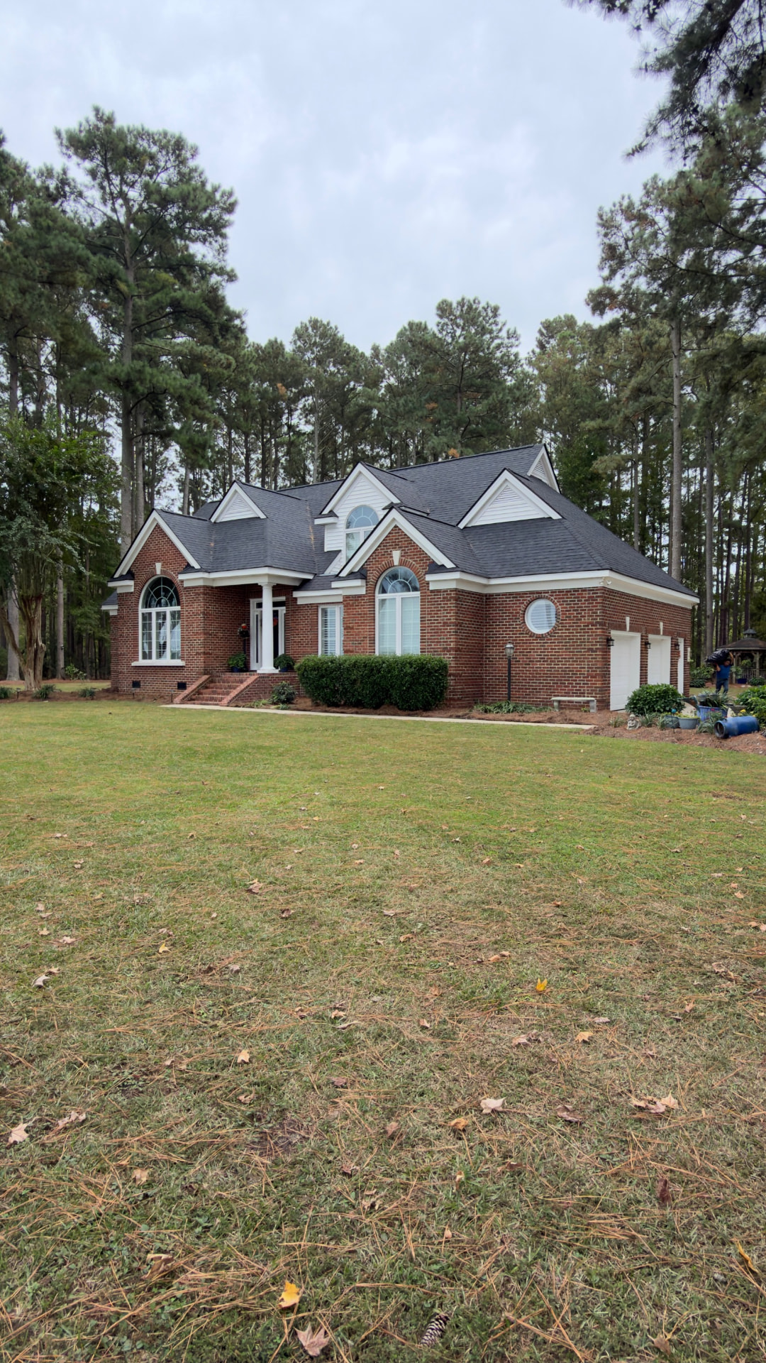 Red brick home with a newly installed dark architectural shingle roof