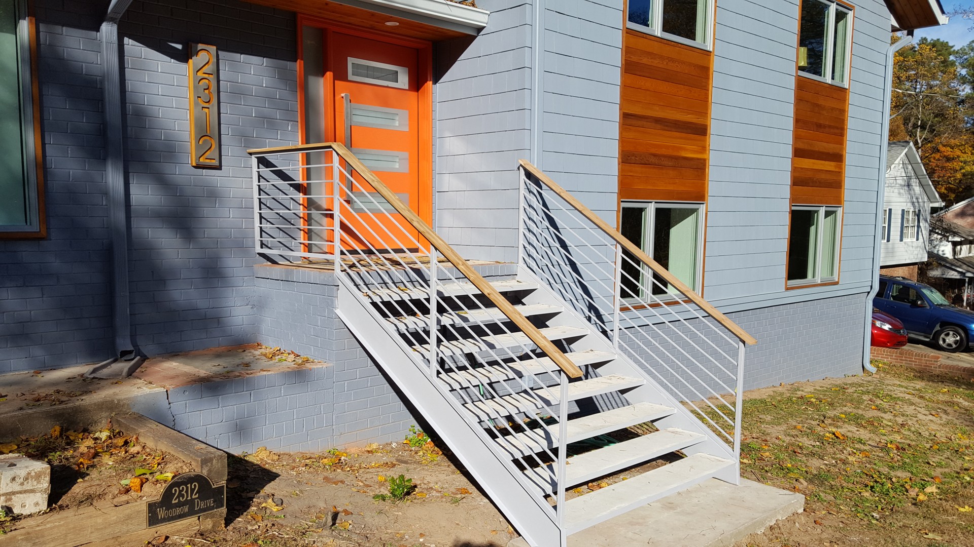 Light-colored steel entry stairs and horizontal railings