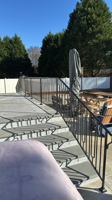 Metal guardrails beside a poolside seating area